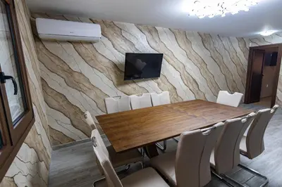 a dining room with a wooden table and chairs at Комплекс Родопска среща - Къщи и Апартаменти in Batak