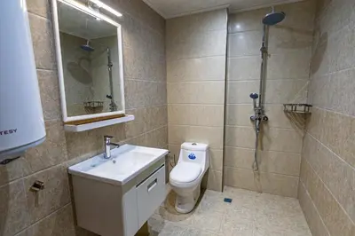 a bathroom with a toilet and a shower and a sink at Комплекс Родопска среща - Къщи и Апартаменти in Batak