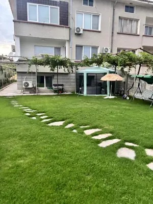 a grassy yard with stepping stones in front of a building at Къща за гости Elion House in Hisarya