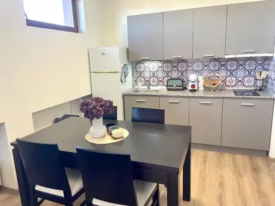 a kitchen with a black table and chairs and a refrigerator at Mountain Escape in Green Life Bansko by SI Stay in Bansko