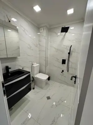a white bathroom with a toilet and a sink at Grand Trio Apartment in Plovdiv