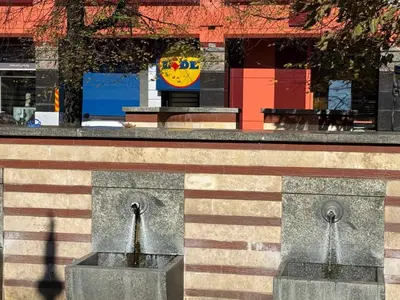 a fountain in front of a building with a clock at Апартамент 36 in Sofia