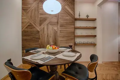 a dining room table with chairs and a bowl of fruit on it at Luxury and stylish apartment in the heart of the city in Sofia