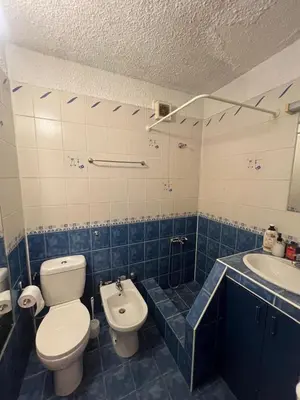 a blue and white bathroom with a toilet and a sink at Cozy apartment with balcony and panoramic view in Sofia