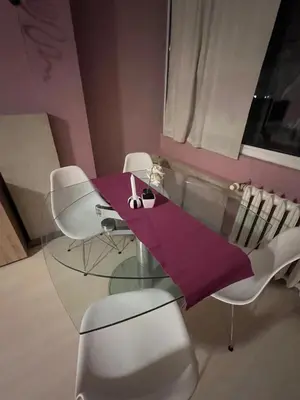 a dining room with a glass table and white chairs at Cozy apartment with balcony and panoramic view in Sofia