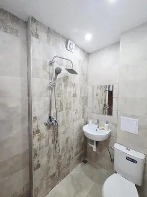 a bathroom with a shower and a toilet and a sink at Слънчев апартамент 44 ет 3 in Sandanski