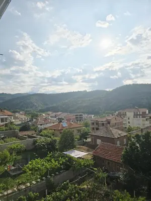 a view of a city with mountains in the background at Слънчев апартамент 44 ет 3 in Sandanski