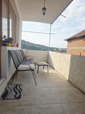 a patio with a bench and a table on a balcony at Слънчев апартамент 44 ет 3 in Sandanski
