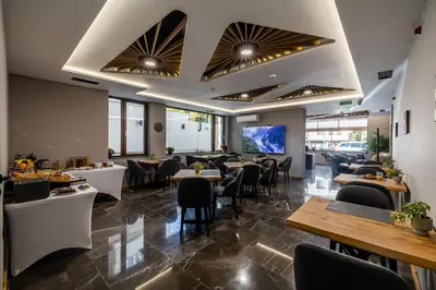 a restaurant with tables and chairs and a bar at Acacia Hotel in Sofia
