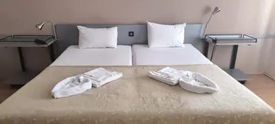 two pairs of white shoes sitting on a bed at ATM Hotel in Sofia