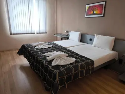 a hotel room with a bed with two towels on it at ATM Hotel in Sofia