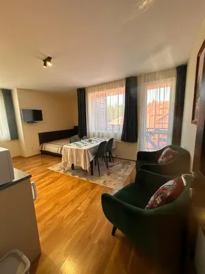 a living room with a bed and a table and chairs at Private large apartment in Iglika 2 for 4 people in Borovets