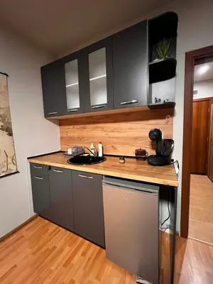 a kitchen with black cabinets and a sink at Apartment near the ski lift with a private parking in Bansko