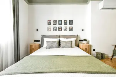 a bedroom with a large bed with two pillows at Lift - Duplex - King Beds - 5min to Vitosha in Sofia