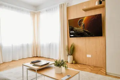 a living room with a table and a tv on a wall at Lift - Duplex - King Beds - 5min to Vitosha in Sofia