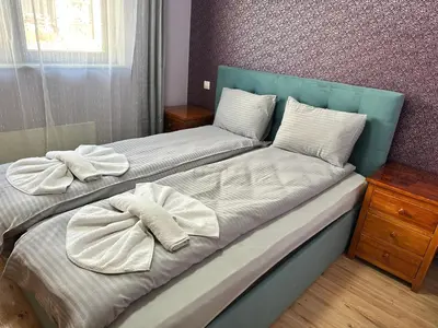 a bedroom with two beds with towels on them at Winslow Highland escape apartment in Bansko