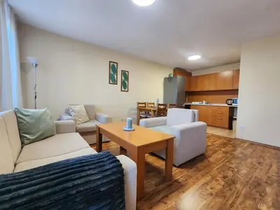 a living room with a couch and a table at Mountain Dream apartment near ski road in Bansko