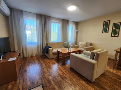 a living room with two couches and a table at Mountain Dream apartment near ski road in Bansko