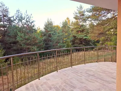 a balcony with a metal fence and trees at Margarita Mountain Apartments in Tsigov Chark