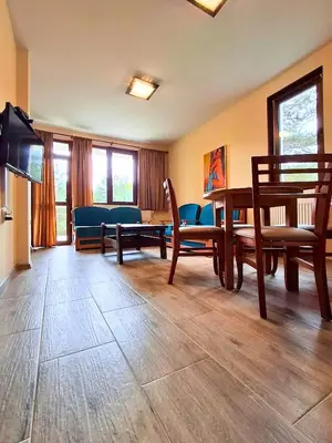 a living room with a table and chairs and a couch at Margarita Mountain Apartments in Tsigov Chark