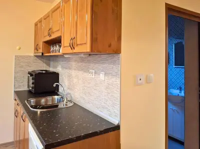 a kitchen with wooden cabinets and a sink at Margarita Mountain Apartments in Tsigov Chark