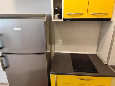 a kitchen with a stainless steel refrigerator and yellow cabinets at Apartment E45 in Borovets Gardens, Borovets resort in Borovets