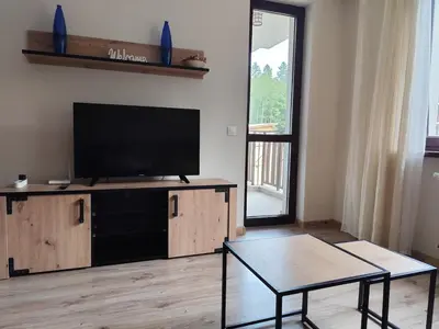 a living room with a flat screen tv and a coffee table at Apartment E45 in Borovets Gardens, Borovets resort in Borovets