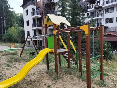 a park with a playground with a slide at Apartment E45 in Borovets Gardens, Borovets resort in Borovets