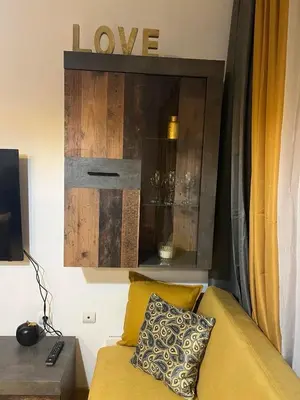 a living room with a yellow couch and a cabinet at ТРИ ПЛАНИНИ ап113 in Razlog
