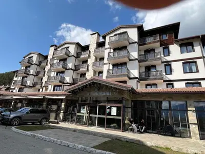 a large apartment building with people sitting outside of it at ТРИ ПЛАНИНИ ап113 in Razlog