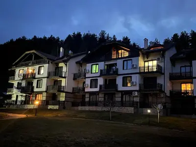 a large apartment building at night with its lights on at ТРИ ПЛАНИНИ ап113 in Razlog