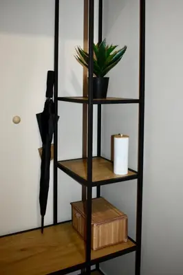 a book shelf with an umbrella and a plant at The Corner apartments in Sofia