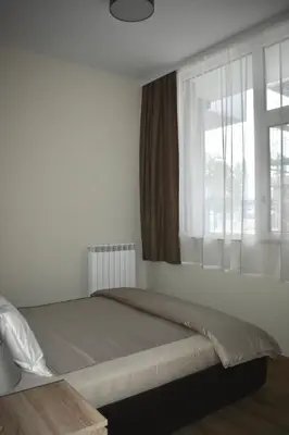 a bedroom with a bed and a window at The Corner apartments in Sofia