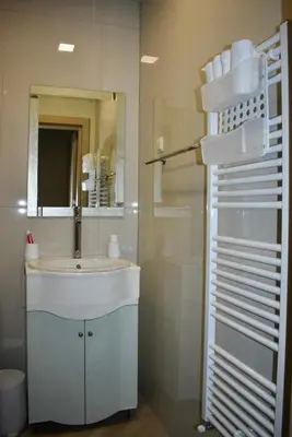 a bathroom with a sink and a mirror and a shower at The Corner apartments in Sofia