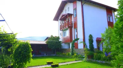 a house with a green yard in front of it at Guest House Simona in Sapareva Banya