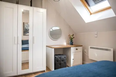 a bedroom with a bed and a desk and a skylight at ARHEYA 2 apart АРХЕЯ 2 апартамент за гости in Karlovo