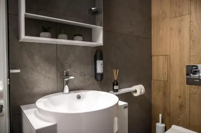 a bathroom with a white sink in a room at ARHEYA 2 apart АРХЕЯ 2 апартамент за гости in Karlovo