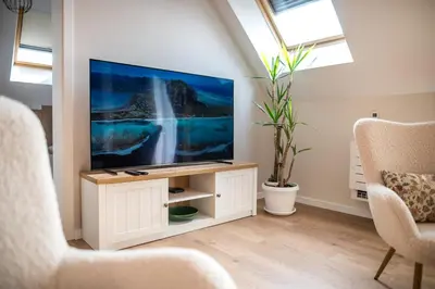a living room with a flat screen tv on a stand at ARHEYA 2 apart АРХЕЯ 2 апартамент за гости in Karlovo