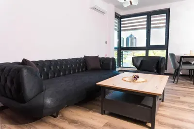 a black couch in a living room with a table at Apartment Maritsa View 2 in Plovdiv