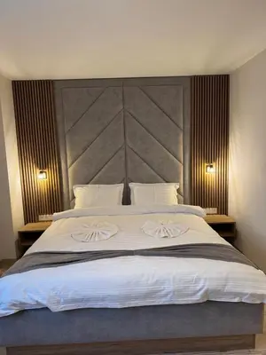 a bedroom with a large bed with two white pillows at Къща за гости Станковата къща in Belchin