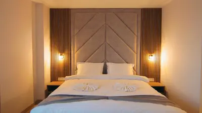 a bedroom with a large white bed with two pillows at Къща за гости Станковата къща in Belchin