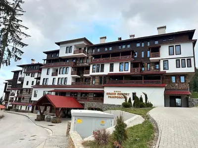 a large building with a parking lot in front of it at Апартаменты Гранд Ризорт с камином и видом на лес in Pamporovo