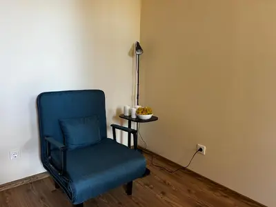 a blue chair sitting in a room with a table at Апартаменты Гранд Ризорт с камином и видом на лес in Pamporovo