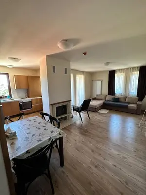 an empty living room with a table and a couch at Апартаменты Гранд Ризорт с камином и видом на лес in Pamporovo
