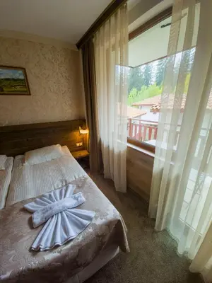 a bedroom with a bed with a large window at Апартамент Орфинда- Pamporovo in Pamporovo