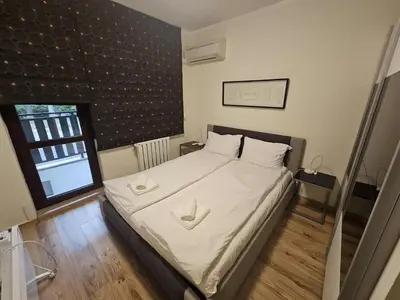 a bedroom with a bed with white sheets and a window at Charming Apartment Borovets Gardens D16 in Samokov