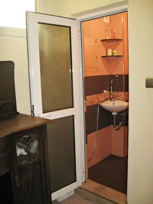 a bathroom with a glass door leading to a sink at Maritsa River Apartment in Plovdiv