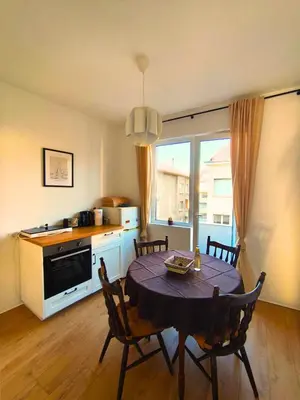 a kitchen and dining room with a table and chairs at Serenity Lodge, close to NDK! in Sofia