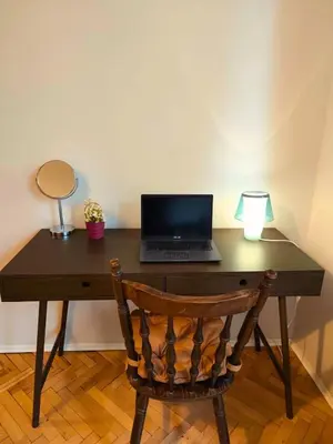 a wooden desk with a laptop computer on top of it at Serenity Lodge, close to NDK! in Sofia