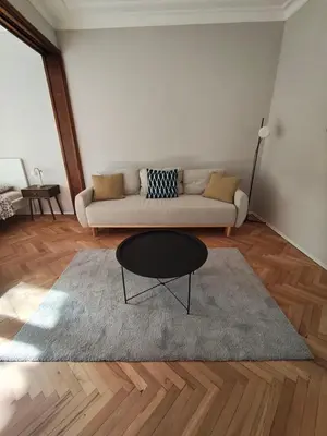 a living room with a couch and a table at Serenity Lodge, close to NDK! in Sofia